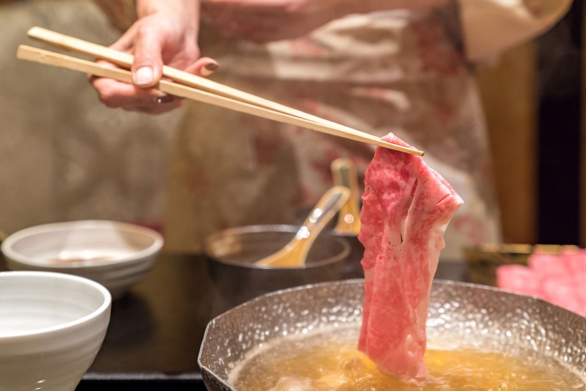 Een klassieke Japanse hete pot, shabu shabu, sudderend dun gesneden rundvlees / Getty