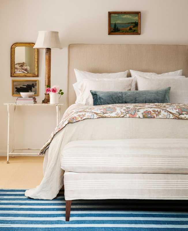 makuuhuone savibeigellä seinällä sininen ja valkoinen raidallinen matto