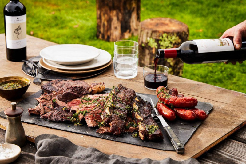   carnes a la parrilla en una mesa con vino afuera