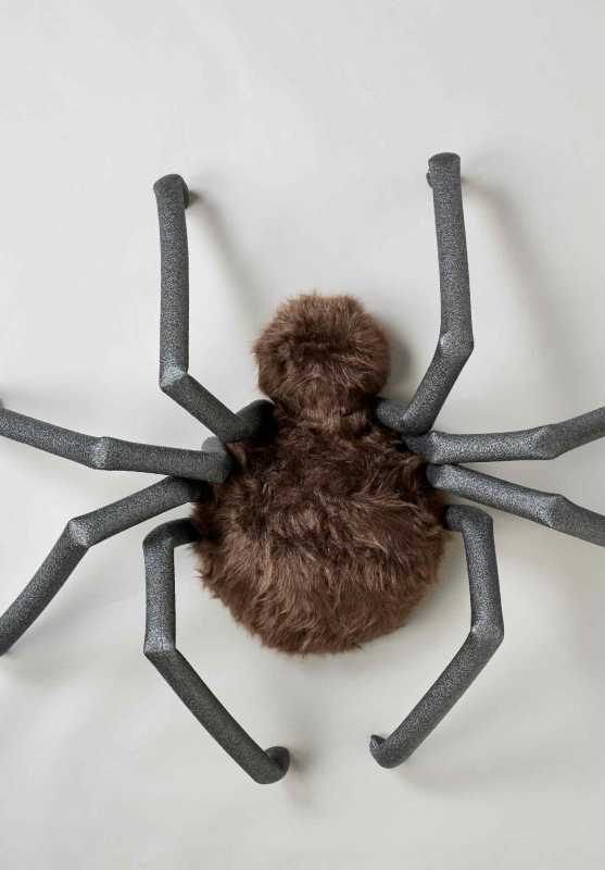 大きなクモの体は茶色のフェイクファーで覆われ、黒い発泡チューブが脚のように折りたたまれています。