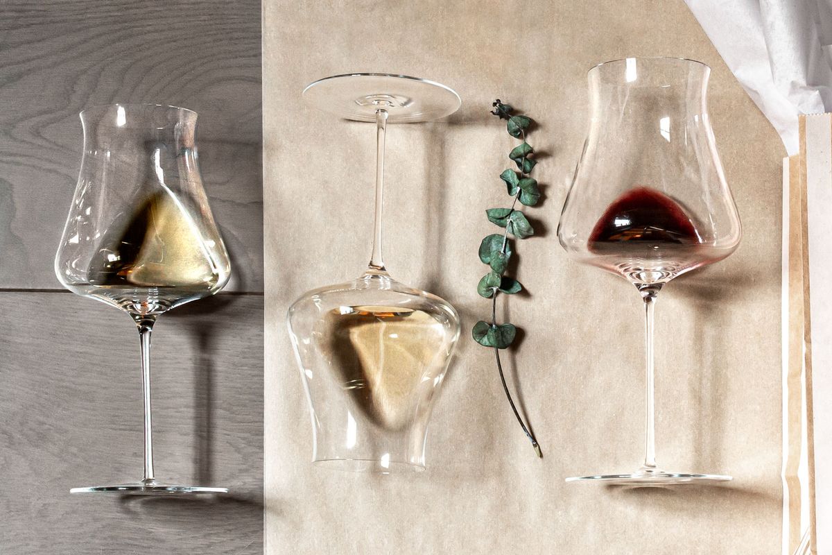 Foto av tre vinglas på deras sida, två med vitt vin, ett med rött