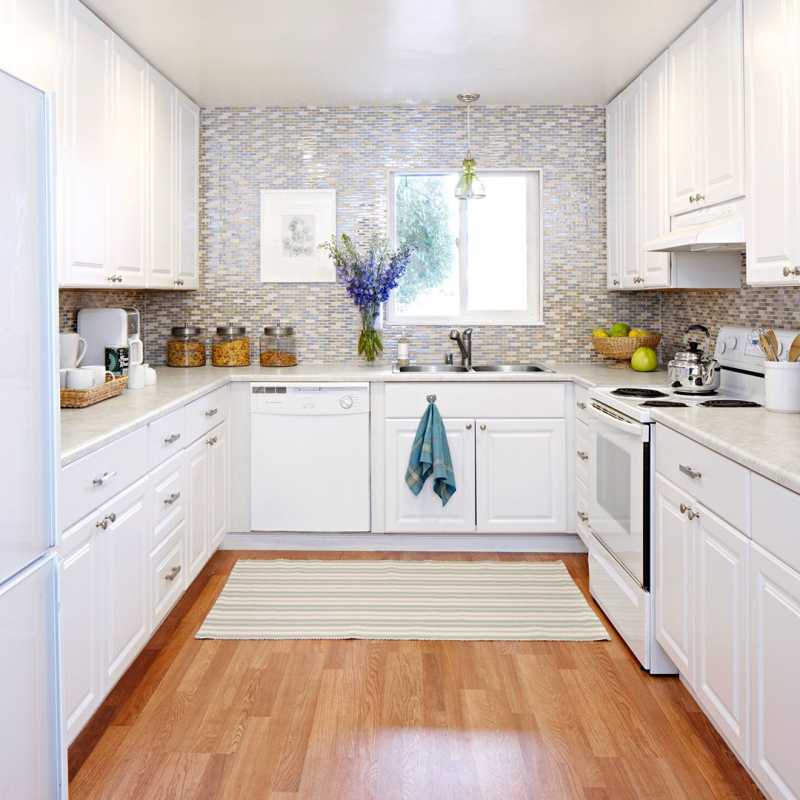 cucina bianca con alzatina in piastrelle grigie e pavimenti in legno