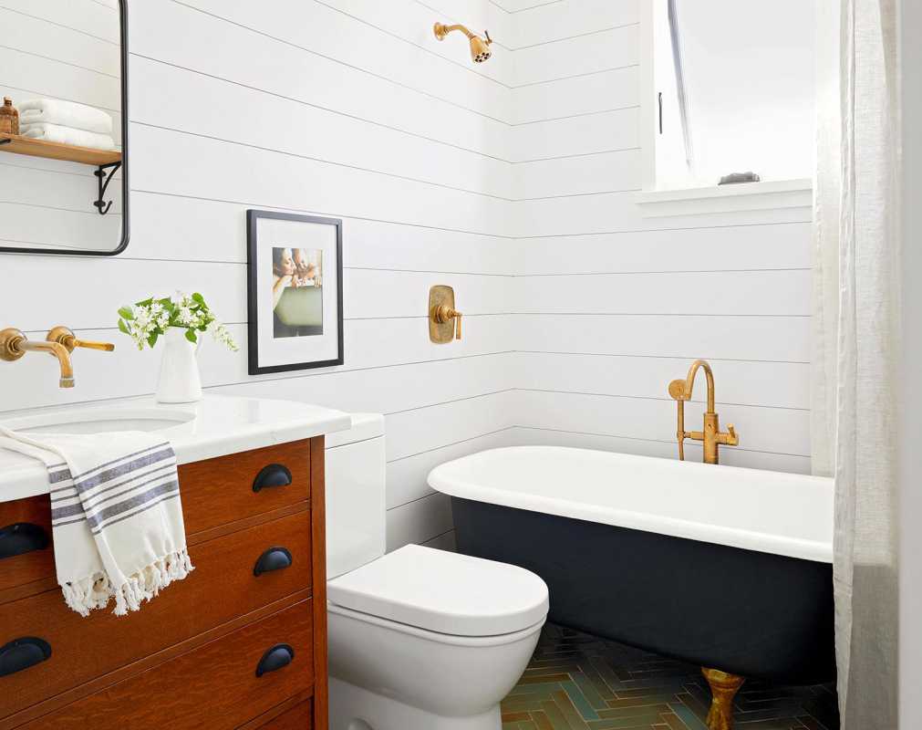 phòng tắm trung tính với bồn tắm có chân đế và những bức tường đóng khung