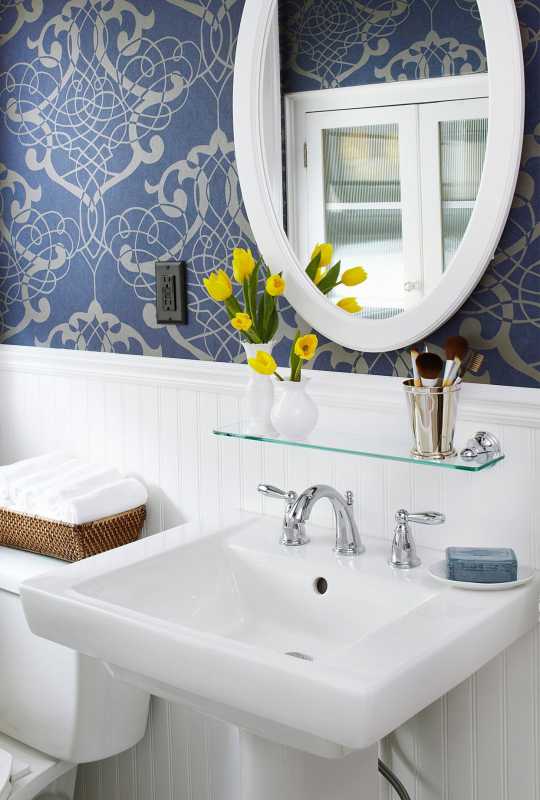 wastafel close-up dan cermin kamar mandi kecil dengan wallpaper biru