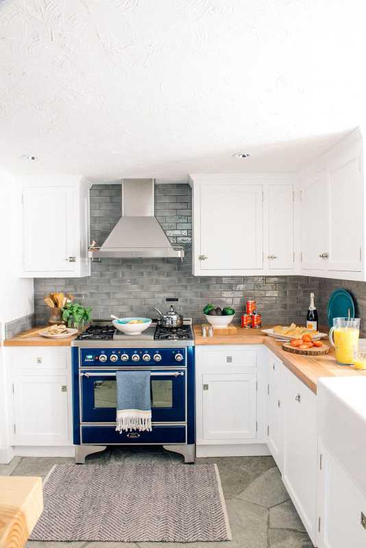 cozinha com armários brancos e fogão azul