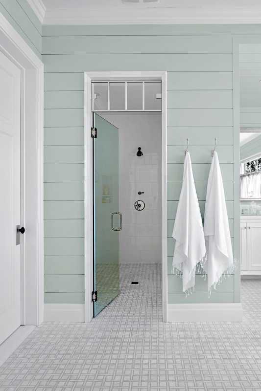 Bad med lyseblå vegger og hengende hvite håndklær