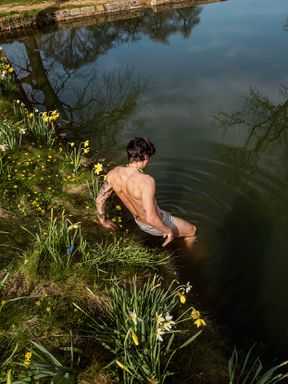 Fotografia de Harry Styles entrando no lago