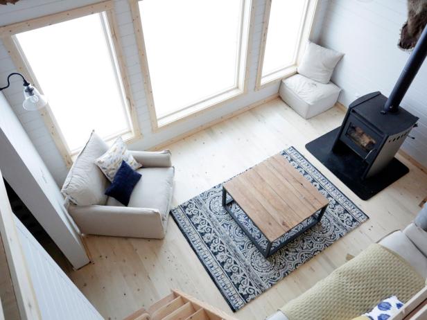 Foto aérea da sala de estar da cabine com cadeira, mesa de centro e fogão