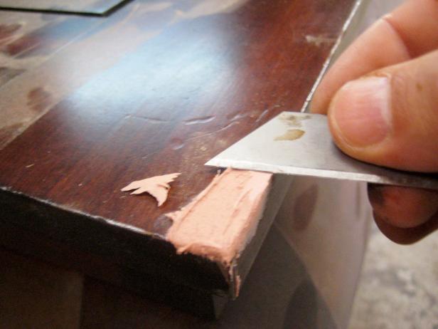 Use una hoja de afeitar para marcar el área de modo que el relleno tenga cierta aspereza para adherirse. En la sección dañada, haga varios cortes pequeños en la madera en un patrón entrecruzado.