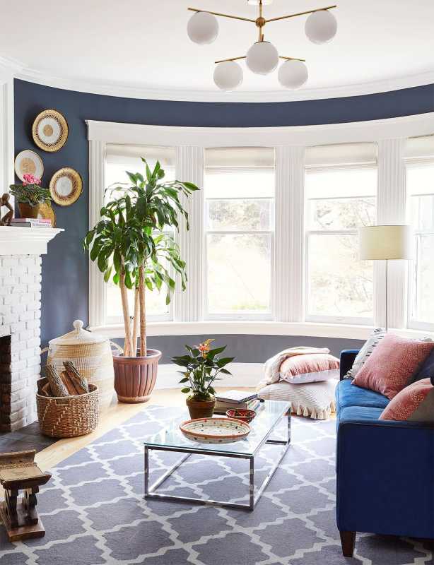 غرفة معيشة عصرية منحنية باللون الأزرق على شكل شجرة وأريكة وطاولة قهوة زجاجية ومدفأة