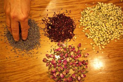 Raaka kukka materiaaleja. Myötäpäivään ylhäältä vasemmalta: kuivatut laventeli, hibiscus, jasmiini ja ruusukukat.