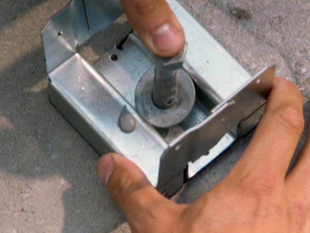 kovové vzpěry připevněné k povrchu kamene nebo betonu