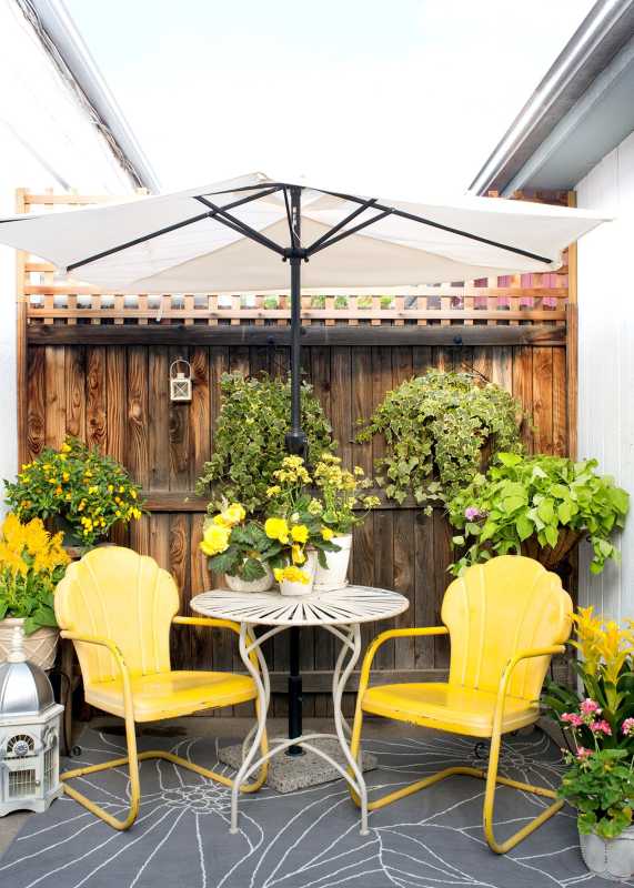 Veranda so žltými stoličkami a bielym stolom