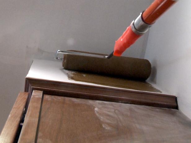 Använd en rullborste för att måla väggen med brun färg.