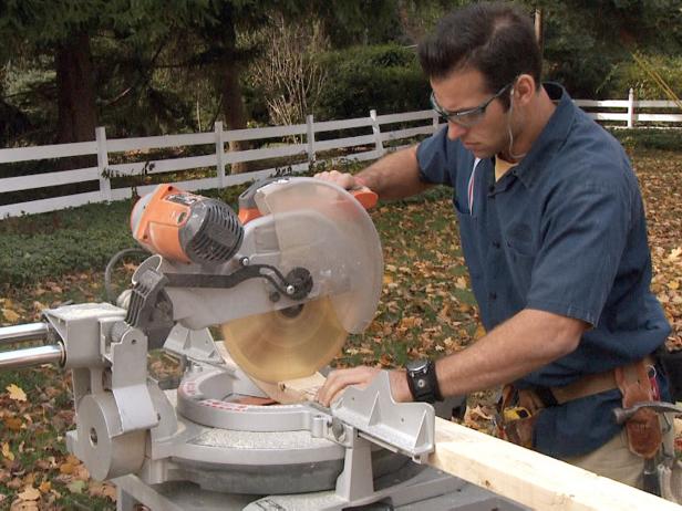 El contractista utilitza una serra per tallar les plaques de paret de fusta en aquest projecte de reparació de cases.