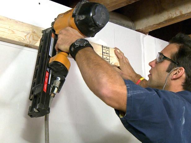 계약자는이 주택 개량 프로젝트에서 목재 벽판을 설치하는 도구를 사용합니다.