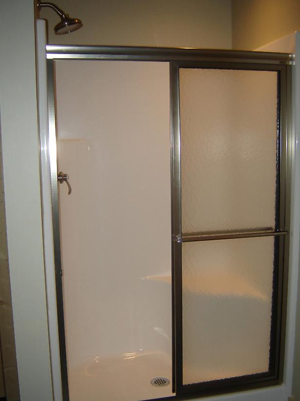 puerta de ducha instalada en ducha prefabricada