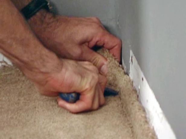 wsunąć dywan pod krawędź ściany za pomocą szydła