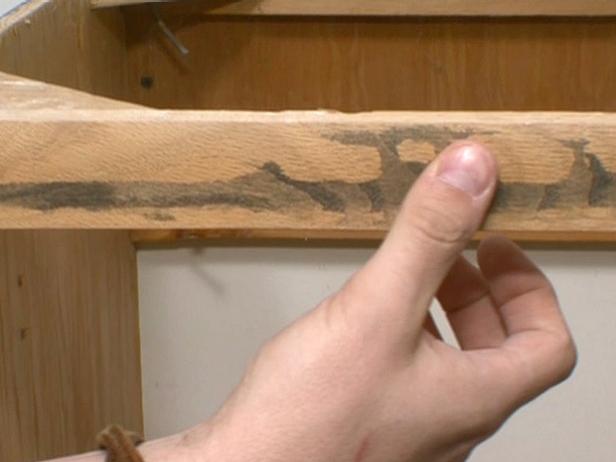 Frotar con los dedos el borde liso de la superficie de madera después de lijar.