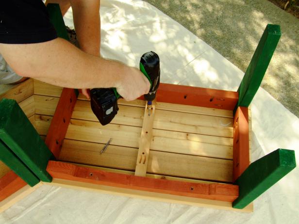 Используйте дрель, чтобы закрепить планки на верхней части скамейки.