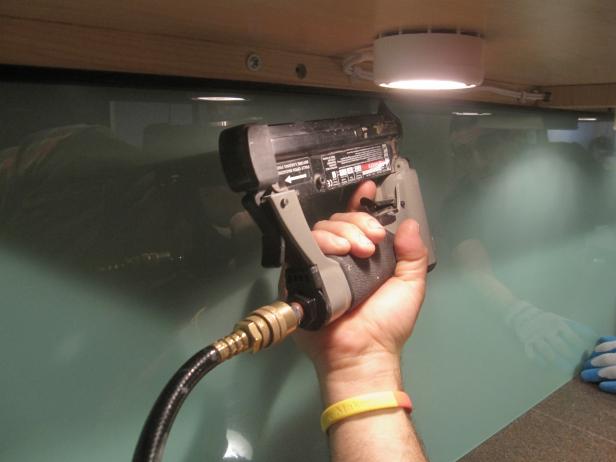 Paggamit ng isang power nailer upang mai-install sa ilalim ng paghuhulma ng gabinete