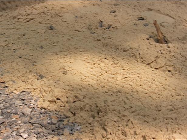 Sandgrund gleichmäßig auf geebnetem Untergrund verteilen
