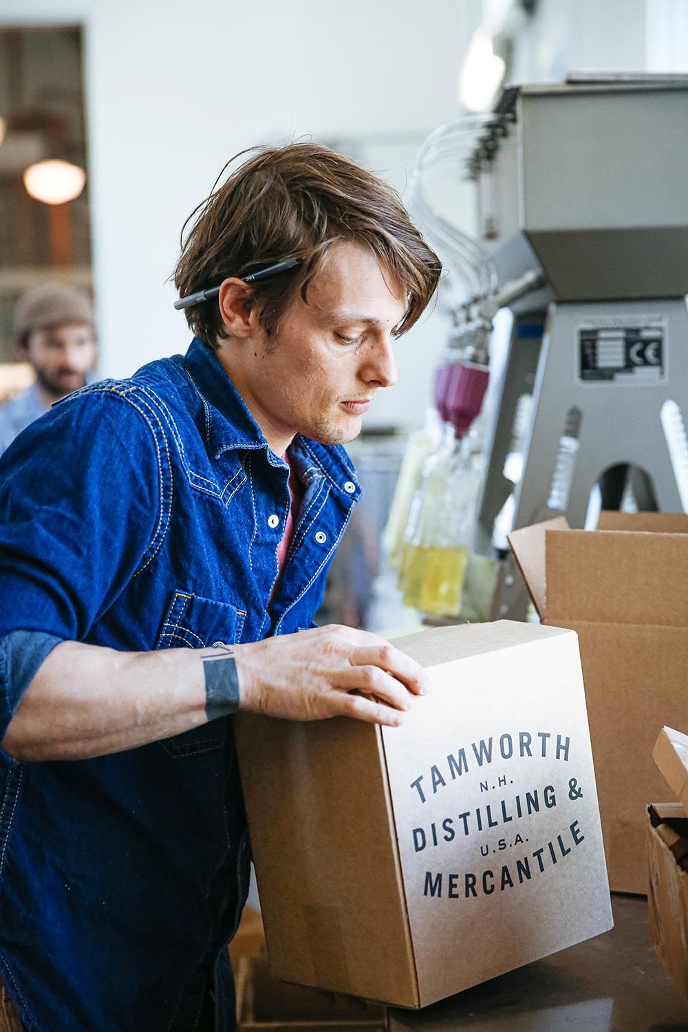 Jamie Oakes de Tamworth Distilling, empacando cajas de bebidas espirituosas en la línea de embotellado