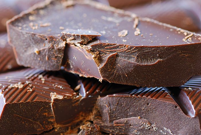 Een close-up van enkele gebroken stukjes donkere chocolade