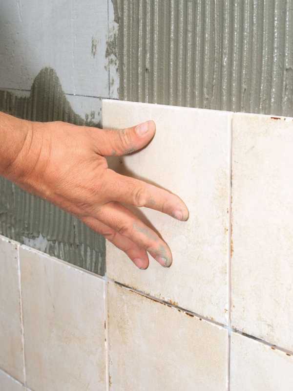 posizionare le piastrelle sulla parete della doccia con malta