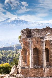 Taorminan antiikkiteatterin rauniot ja pylväät, taustalla Etna-vuori