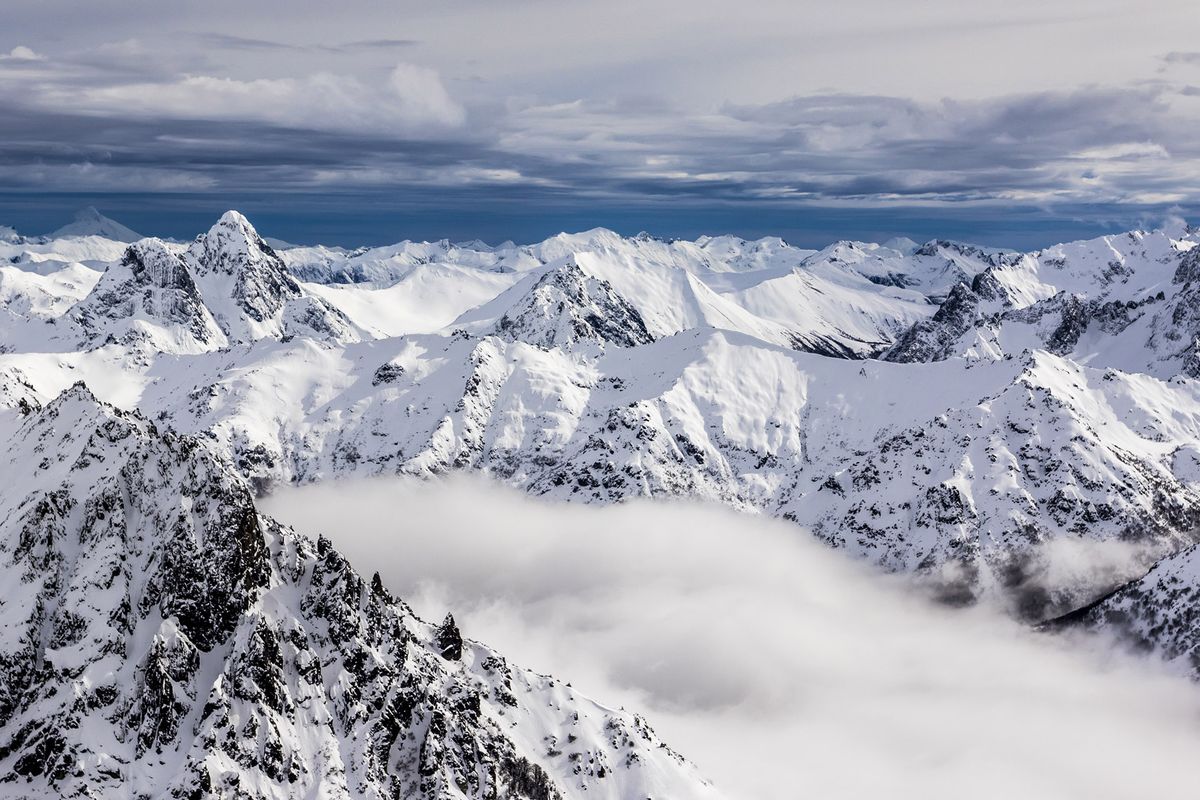 Montagne sotto la neve spessa, sopra la linea delle nuvole