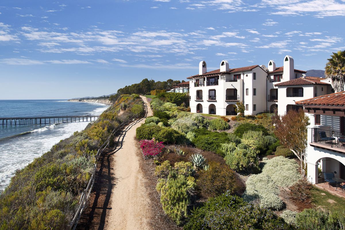 Šetalište uz more kroz kalifornijski xeriscape, zgrade s crvenim pločicama s desne strane