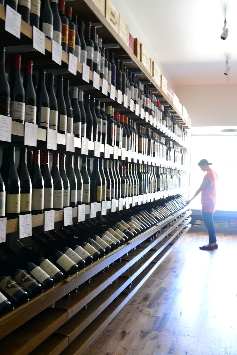 Pelanggan meneliti rak anggur di Underdog Wine Co.