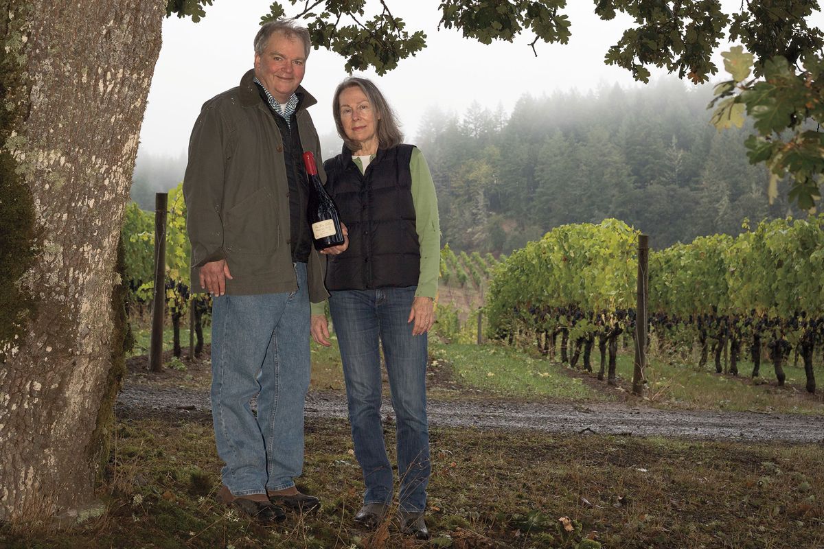 Dick dan Deirdre Shea berdiri di bawah pohon di depan kebun anggur