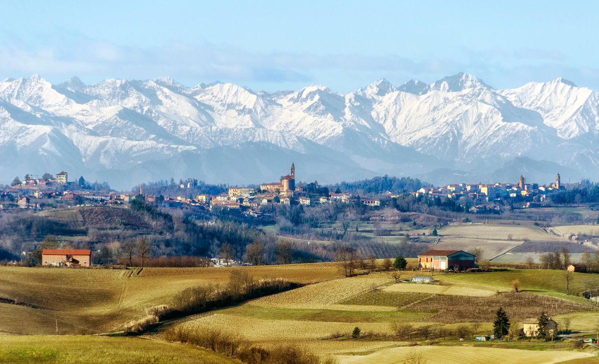 En italiensk by med snötäckta berg i bakgrunden