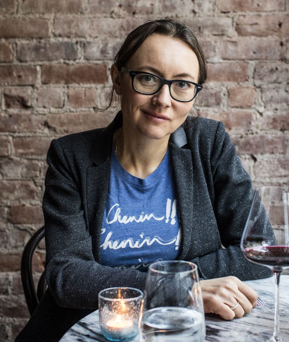 Naine vabaajarõivastuses, istub marmorist laua taga, klaas punast veini ja klaas vett